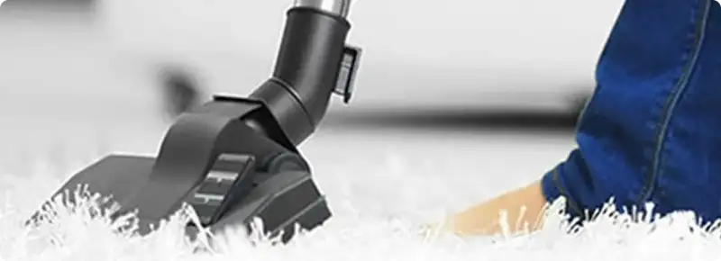 Close-up of a professional vacuuming a white carpet in Saint Paul.